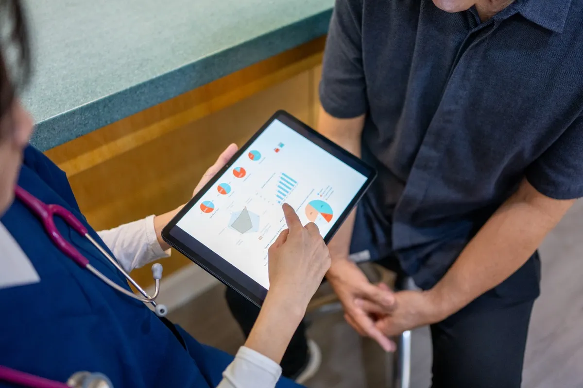 Doctor reviewing blood work data on a tablet with a patient